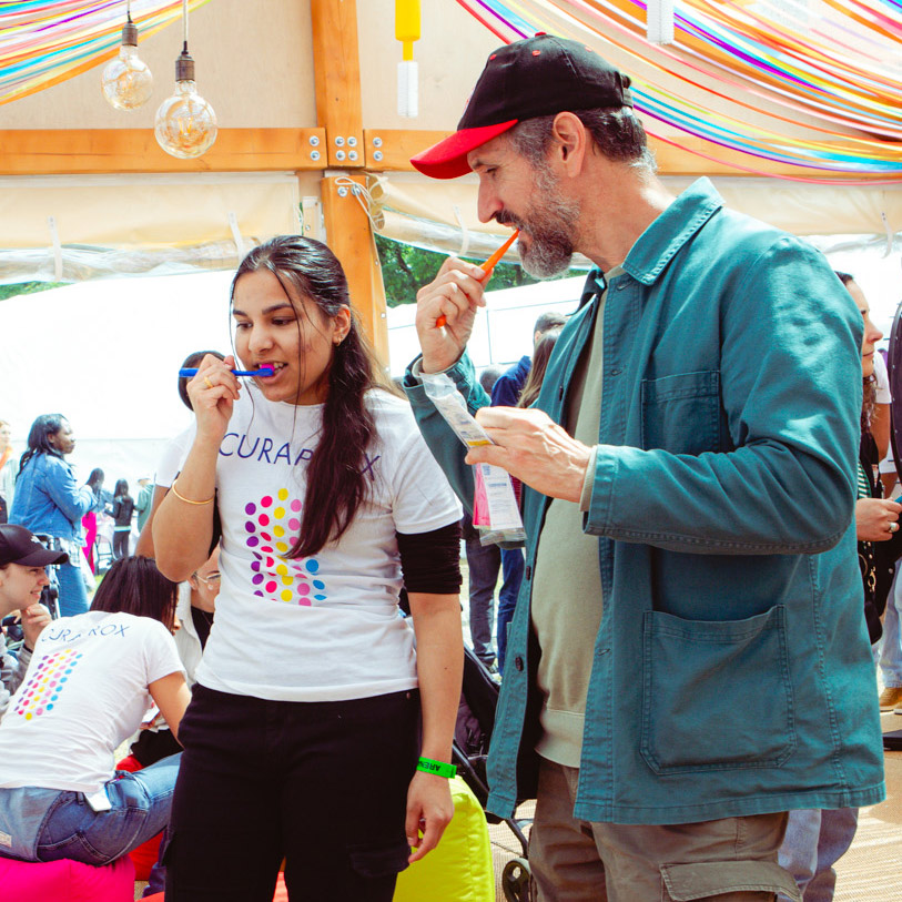 Two people brushing their teeth at the Curaprox event