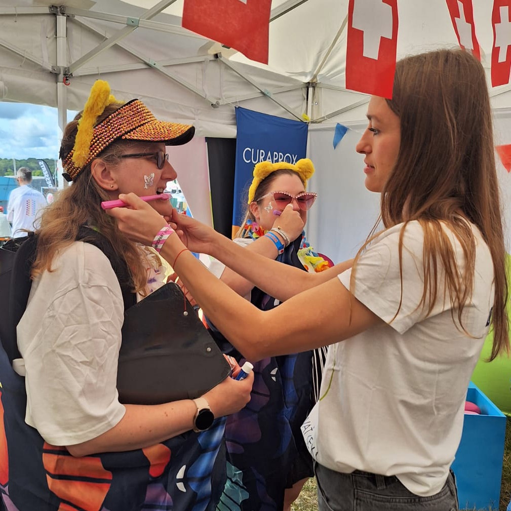 A woman brushing the teeth of another woman at the Curaprox event